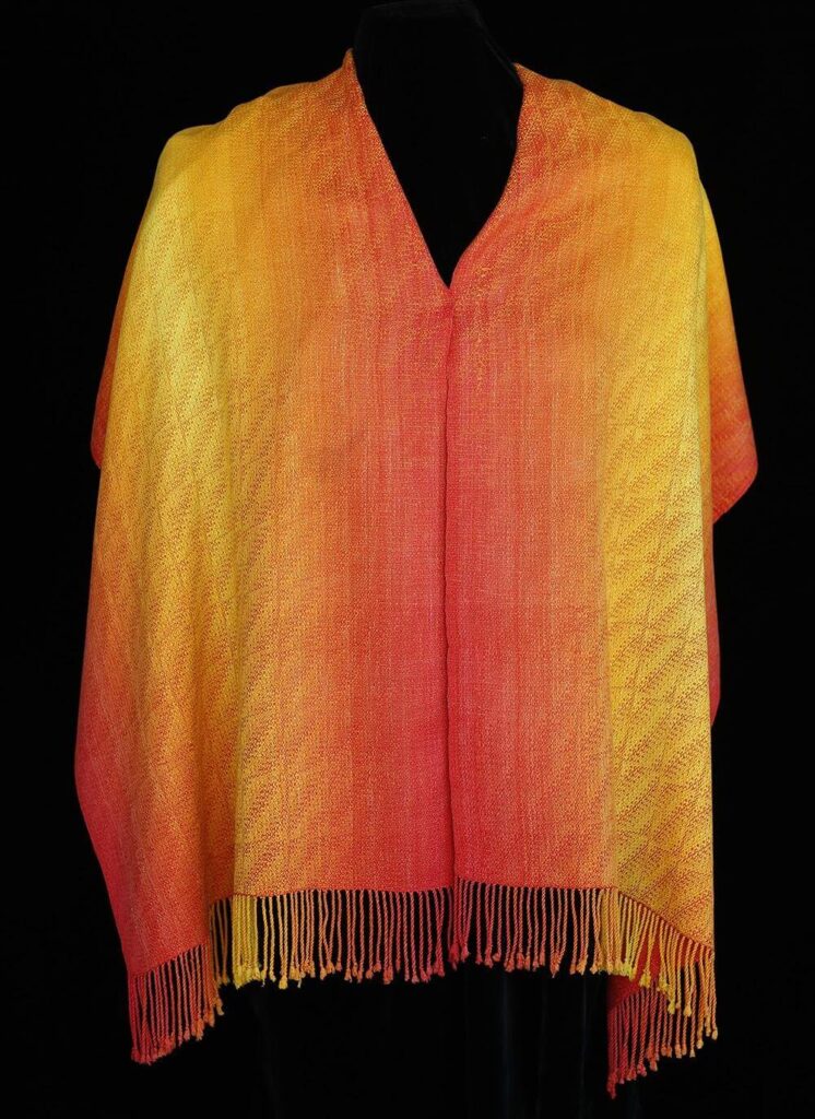 Yellow orange and red blended in a shawl that also has an 8 shaft weave pattern