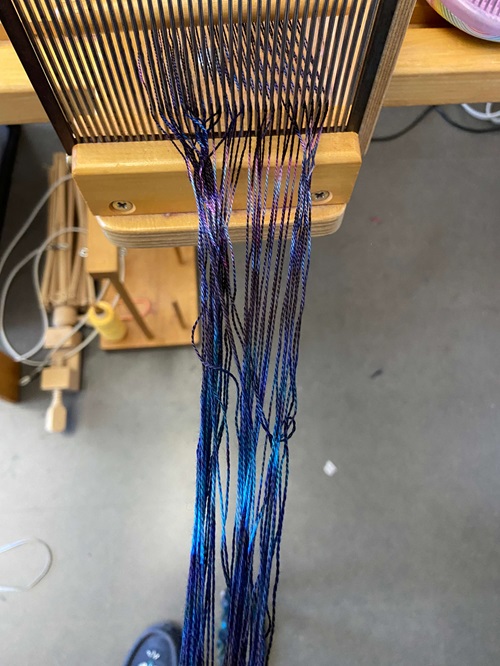 A section of blue warp that has some tangles in it