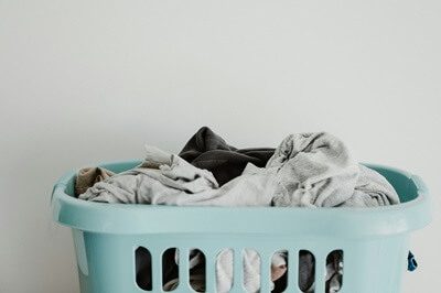 a mint green laundry basket filled with clothing