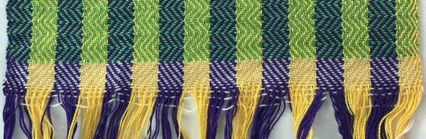 woven fabric with wide stripes of yellow-green and blue -purple in the warp, a small portion woven with the yellow-green as weft, as well as some woven with a green weft