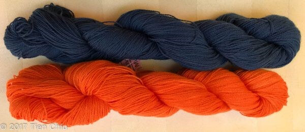 Two twisted skeins of yarn, one is a deep navy, the other is a bright orange